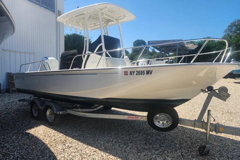 Slide: The Image of 2024 Boston Whaler 210 Montauk boat on trailer, parked outdoors. - 16