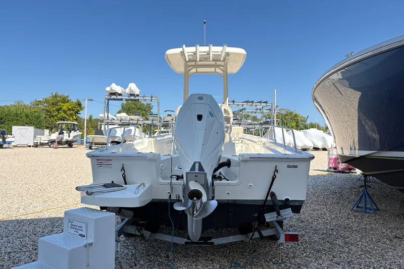 Slide: The Image of 2024 Boston Whaler 210 Montauk boat on trailer in sunny outdoor setting. - 2
