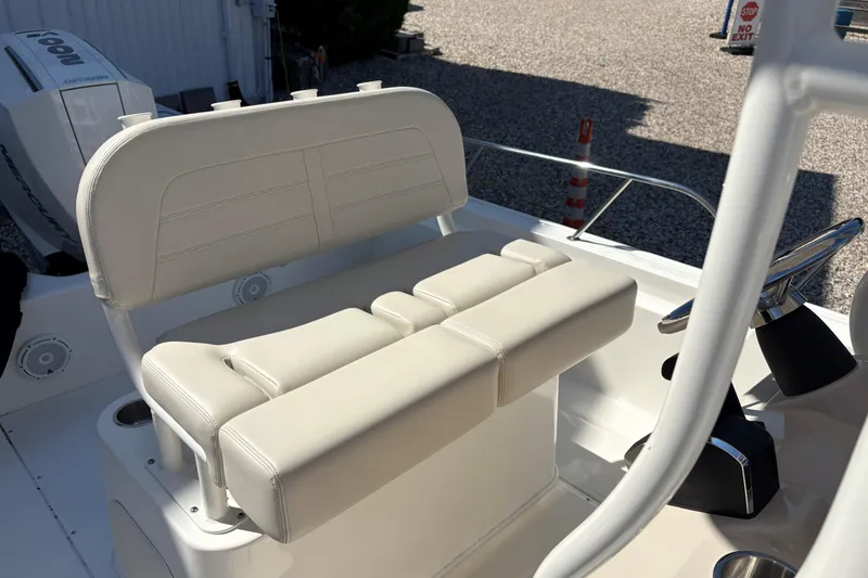 Slide: The Image of 2024 Boston Whaler 210 Montauk boat interior with beige seating and steering wheel. - 7