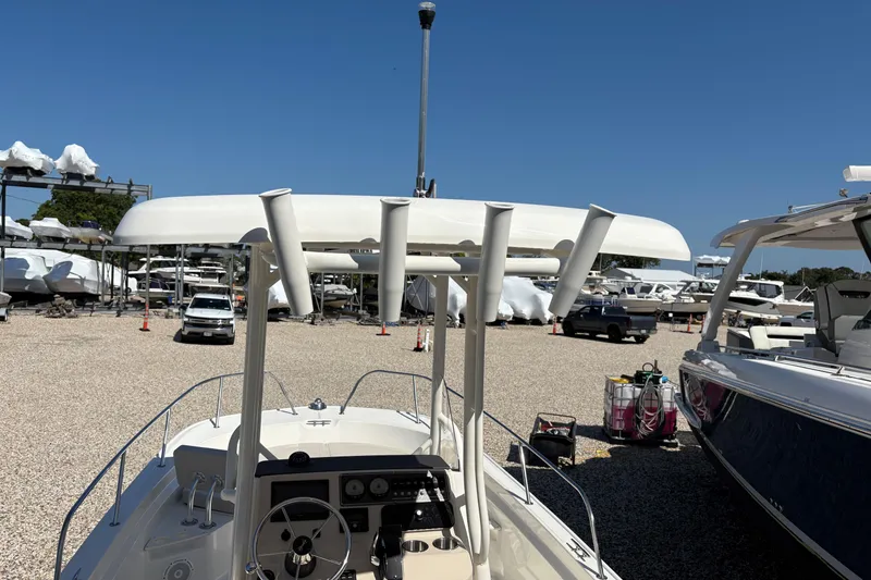 Slide: The Image of 2024 Boston Whaler 210 Montauk boat in a marina with clear blue sky. - 9