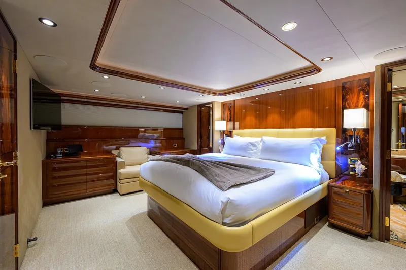 Slide: The Image of Luxurious bedroom interior on 2014 Westport 112 yacht, featuring elegant wood finishes and plush bedding. - 30
