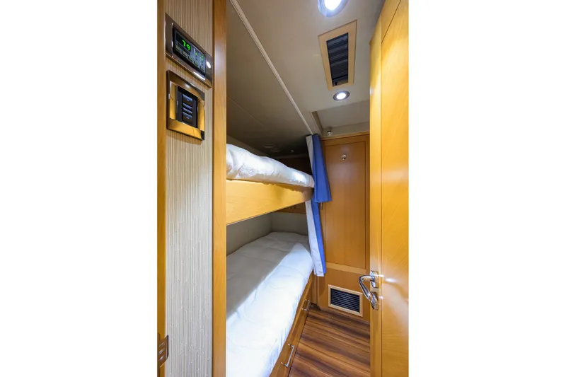 Slide: The Image of Cozy bunk bed cabin in 2014 Westport 112 yacht, featuring wood paneling and modern lighting. - 78