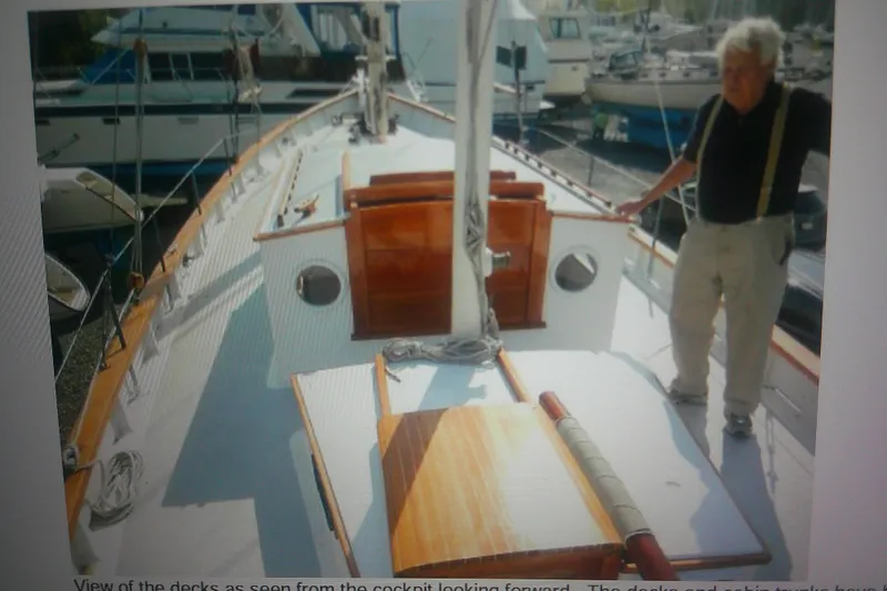 Slide: The Image of 1955 Custom Gaff Rigged Ketch with wooden deck, docked at marina, person standing on board. - 10