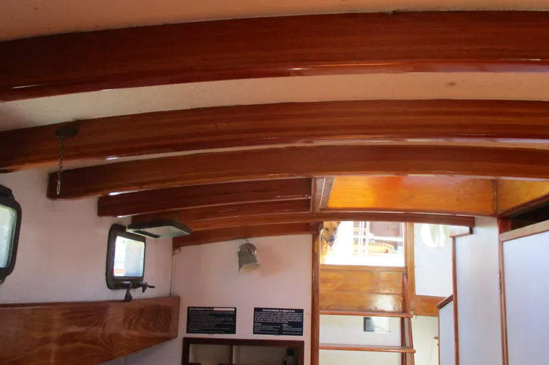 Slide: The Image of Interior of 1955 Custom Gaff Rigged Ketch with wooden beams and portholes. - 11