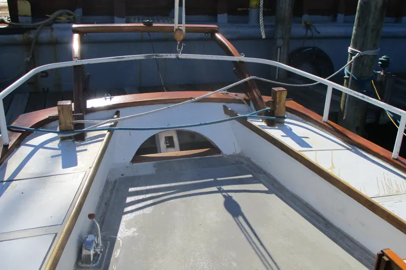 Slide: The Image of 1955 Custom Gaff Rigged Ketch deck with wooden railings and rigging details. - 24