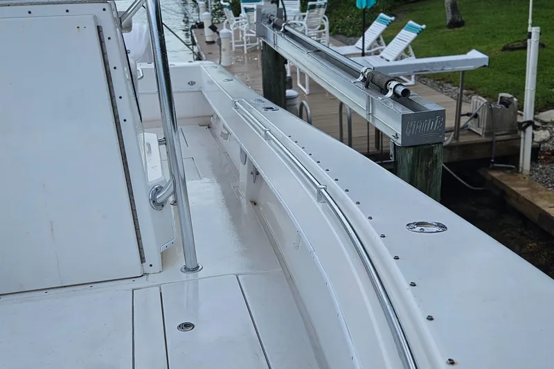 Slide: The Image of 2002 Contender 31 Open boat docked by waterfront with palm trees and umbrellas. - 15