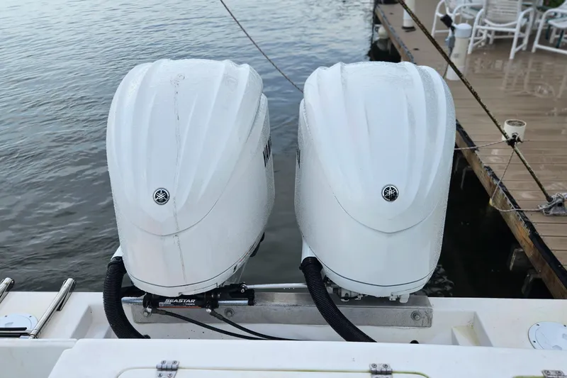 Slide: The Image of 2002 Contender 31 Open boat with American flag decal, docked under cloudy skies. - 3