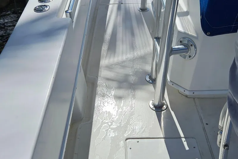 Slide: The Image of 2002 Contender 31 Open boat with T-top and Yamaha engine, docked under a cloudy sky. - 5