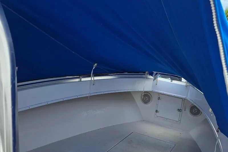 Slide: The Image of 2002 Contender 31 Open boat with blue canopy covering the deck area. - 50