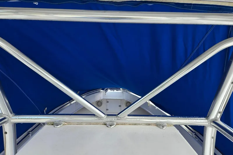 Slide: The Image of 2002 Contender 31 Open boat interior with blue canopy and storage compartment. - 51