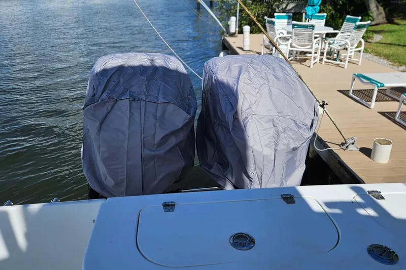 Slide: The Image of 2002 Contender 31 Open boat with blue cover and metal railing near waterway. - 54