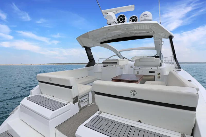 Slide: The Image of 2018 Cruisers Yachts 390 EC luxury boat interior with seating and table on open water. - 20