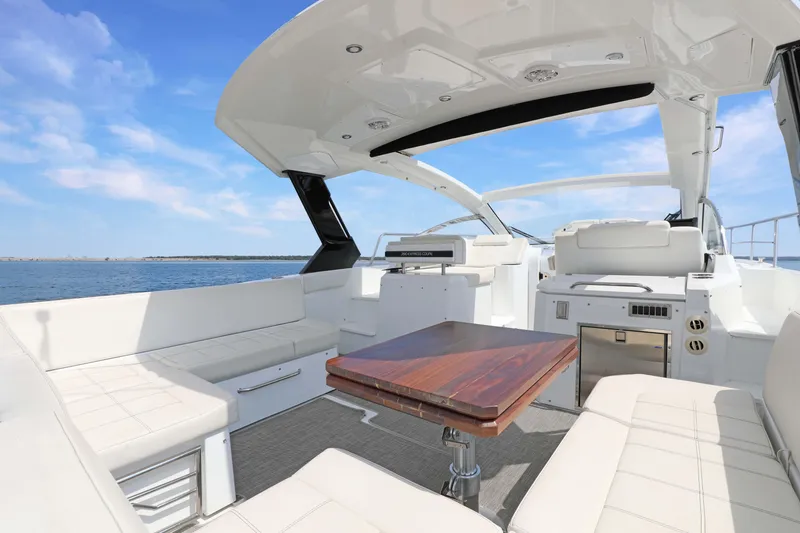 Slide: The Image of Luxurious 2018 Cruisers Yachts 390 EC interior with elegant seating and wooden table, ocean view. - 24