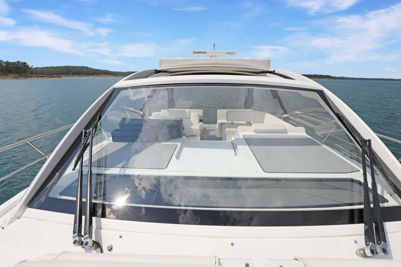 Slide: The Image of 2018 Cruisers Yachts 390 EC on serene water, showcasing sleek design and spacious deck. - 36