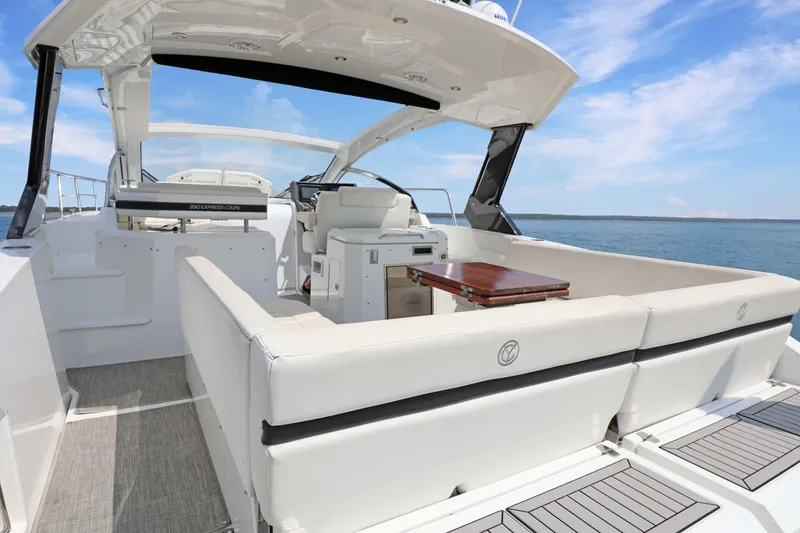 Slide: The Image of 2018 Cruisers Yachts 390 EC interior with seating and table, overlooking serene ocean view. - 44