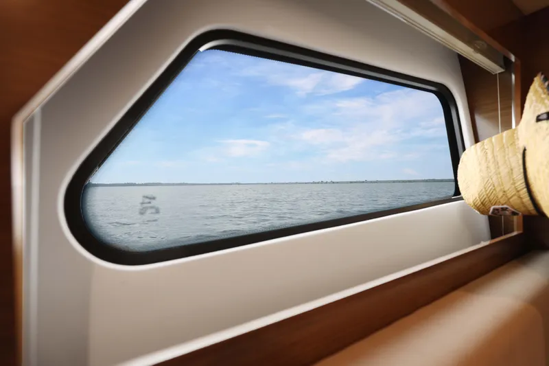 Slide: The Image of View from 2018 Cruisers Yachts 390 EC window, overlooking serene ocean and blue sky. - 68