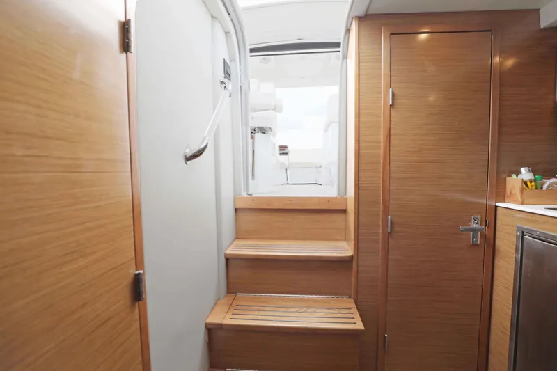 Slide: The Image of Interior view of 2018 Cruisers Yachts 390 EC, featuring wooden stairs and cabinetry. - 69