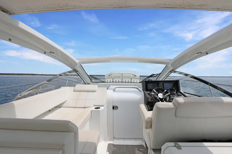 Slide: The Image of 2018 Cruisers Yachts 390 EC interior with luxurious seating and modern helm on open water. - 31