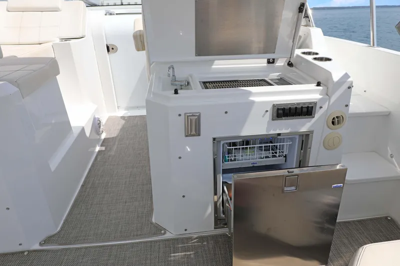 Slide: The Image of 2018 Cruisers Yachts 390 EC boat interior with kitchenette and open fridge. - 38