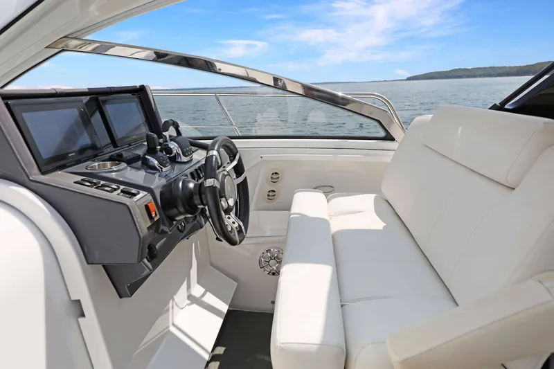 Slide: The Image of 2018 Cruisers Yachts 390 EC helm with white seating and modern controls on open water. - 49