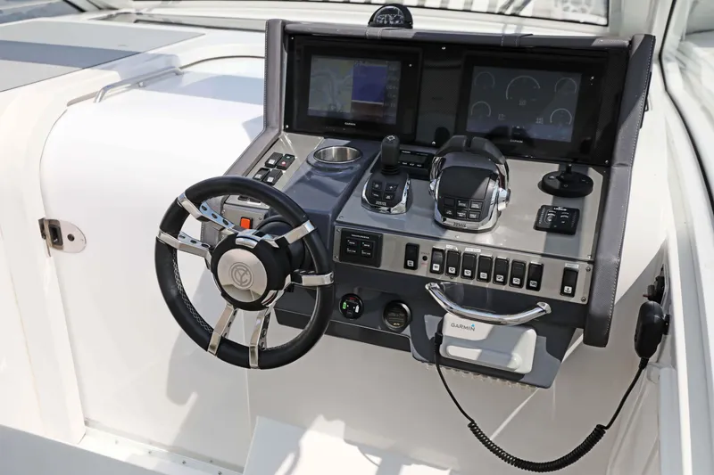 Slide: The Image of 2018 Cruisers Yachts 390 EC helm with advanced navigation controls and steering wheel. - 51