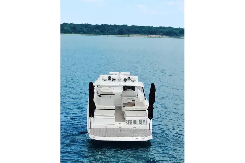 Slide: The Image of 2018 Cruisers Yachts 390 EC on serene blue water, rear view. - 6