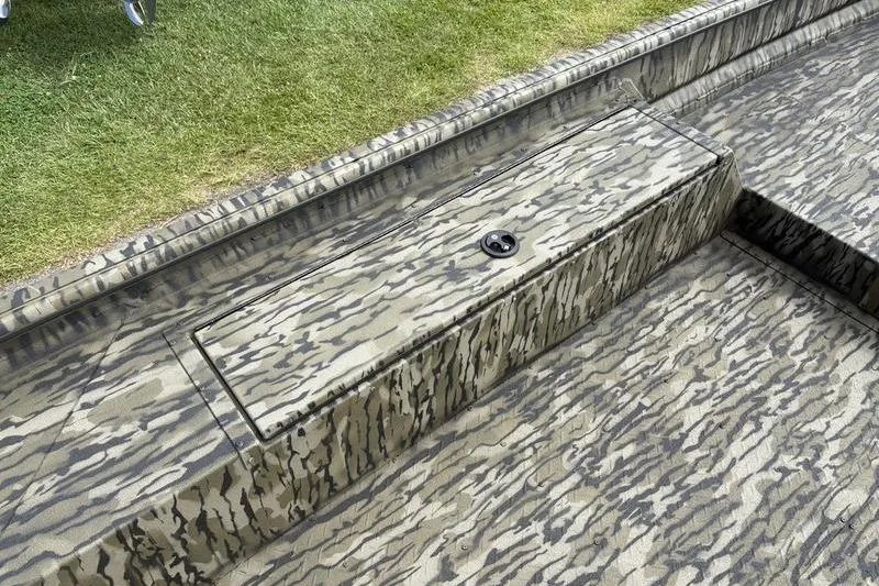 Slide: The Image of 2026 SeaArk DXS 1652 DKLD boat with camouflage pattern, grassy background. - 12