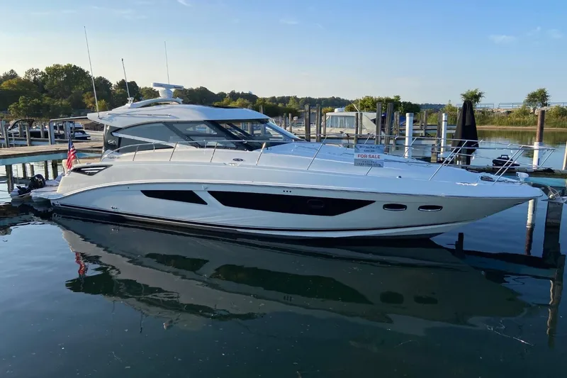 The Image of 2015 Sea Ray 470 Sundancer yacht docked, for sale, reflecting on calm water. - 0