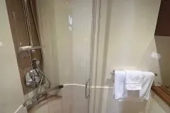 Slide: The Image of Shower area in 2015 Sea Ray 470 Sundancer yacht bathroom with glass door and towel rack. - 32