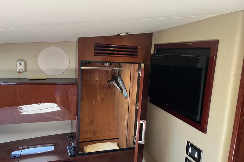 Slide: The Image of 2015 Sea Ray 470 Sundancer interior with wooden closet and wall-mounted TV. - 39