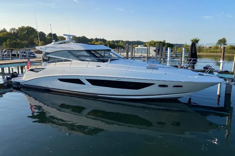 Slide: The Image of 2015 Sea Ray 470 Sundancer yacht docked, for sale, reflecting on calm water. - 58