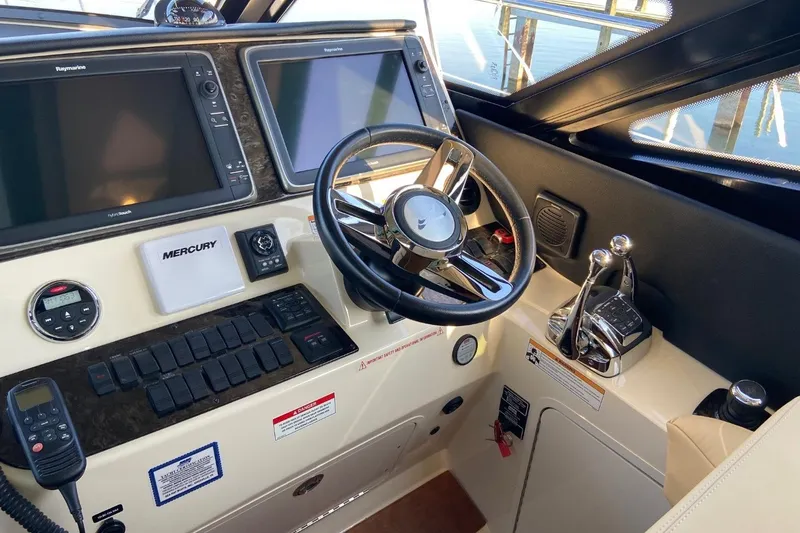 Slide: The Image of Control panel of a 2015 Sea Ray 470 Sundancer yacht with steering wheel and navigation screens. - 7