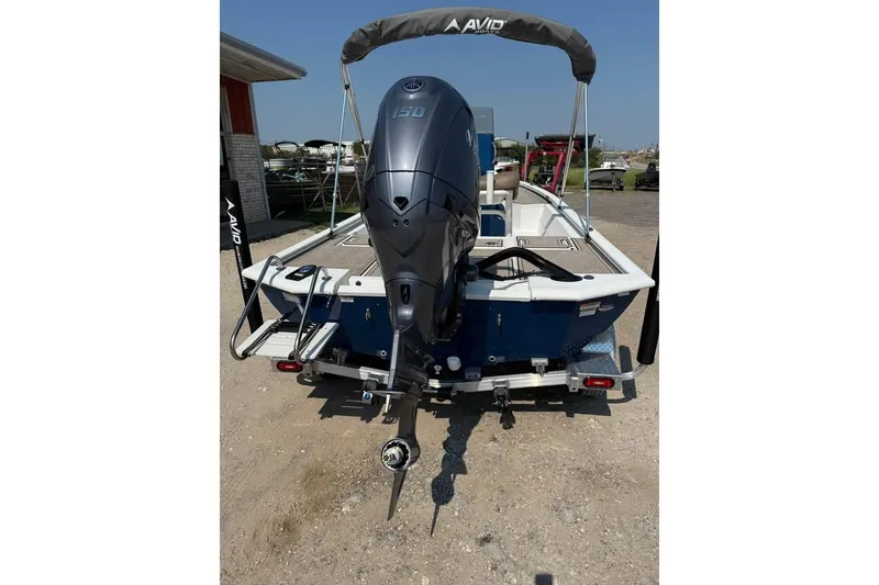 Slide: The Image of 2026 Avid 21 FSX boat with powerful outboard motor, parked on a trailer. - 3