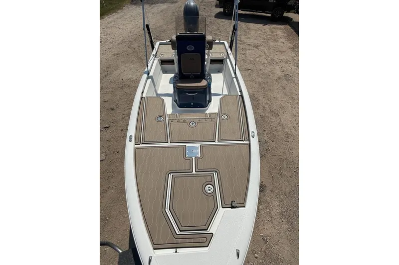 Slide: The Image of 2026 Avid 21 FSX boat with tan deck, parked on dirt ground. - 4