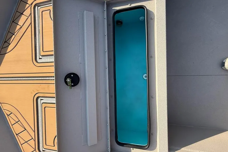 Slide: The Image of Avid 18 Rogue SC 2026 boat interior with storage compartment and patterned flooring. - 7