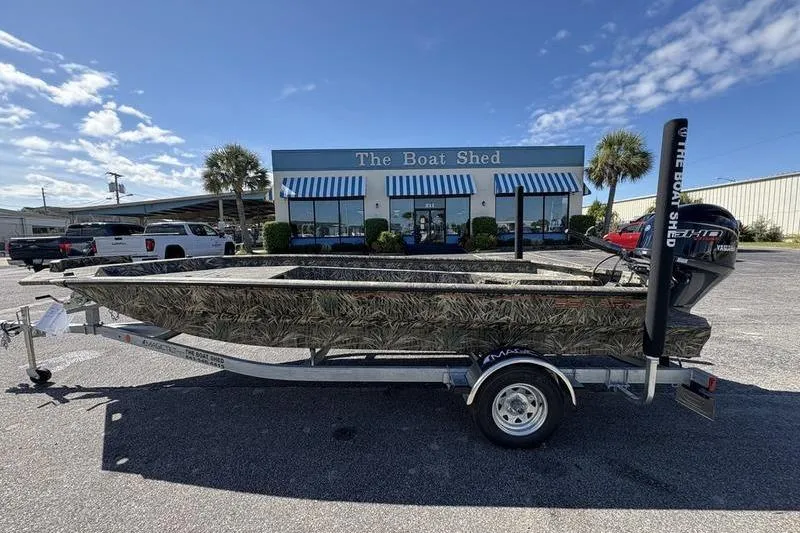 The Image of 2026 SeaArk 1960 Slayer boat on trailer outside The Boat Shed under blue sky. - 1