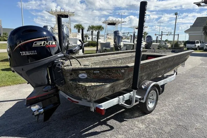 Slide: The Image of 2026 SeaArk 1960 Slayer boat with Yamaha engine on trailer, parked outdoors. - 4