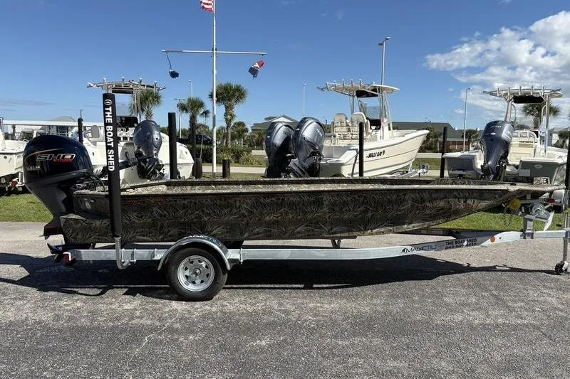 Slide: The Image of 2026 SeaArk 1960 Slayer boat on trailer, camo design, parked outdoors. - 5