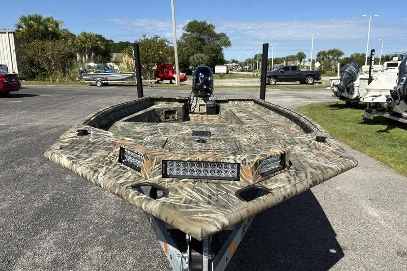 Slide: The Image of 2026 SeaArk 1960 Slayer boat with camouflage design and LED lights in a parking lot. - 7