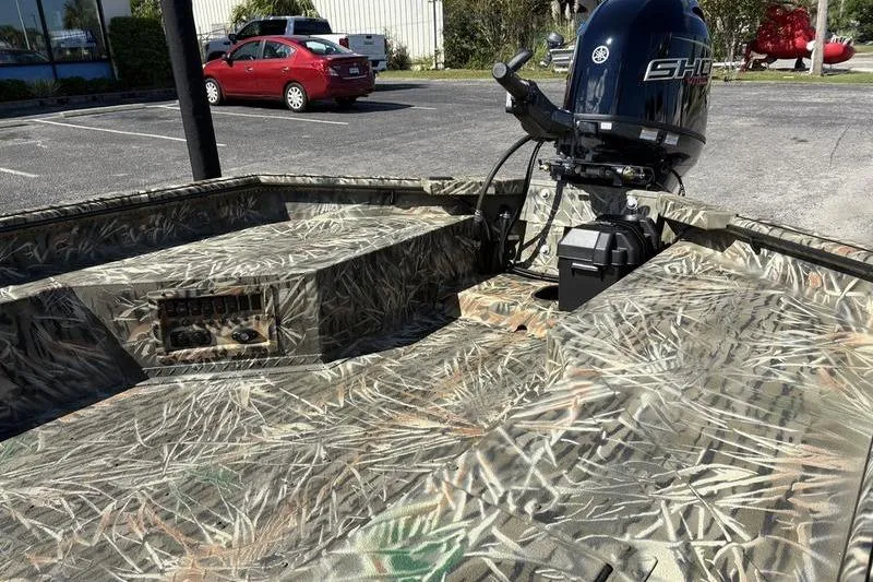 Slide: The Image of 2026 SeaArk 1960 Slayer boat with camouflage design and powerful outboard motor. - 9