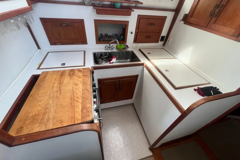 Slide: The Image of Compact kitchen in 1994 Zimmerman Marine Z36 Sedan Cruiser with wooden cabinetry and countertops. - 3