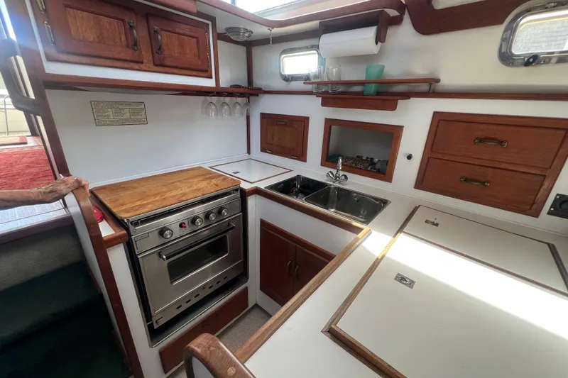 Slide: The Image of 1994 Zimmerman Marine Z36 Sedan Cruiser kitchen with wood cabinetry and stainless steel appliances. - 9