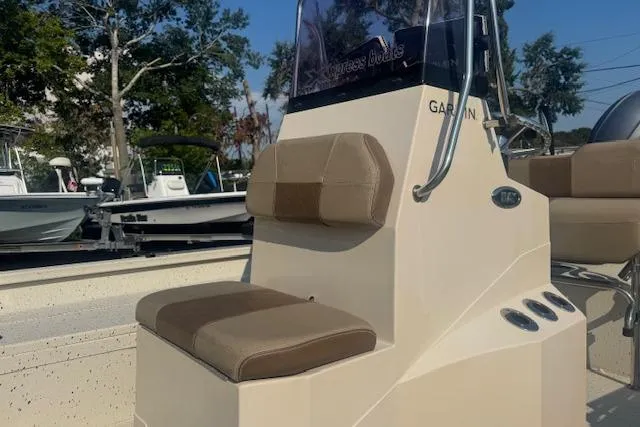 Slide: The Image of 2019 Xpress H20 boat with beige seating and console, parked outdoors. - 16