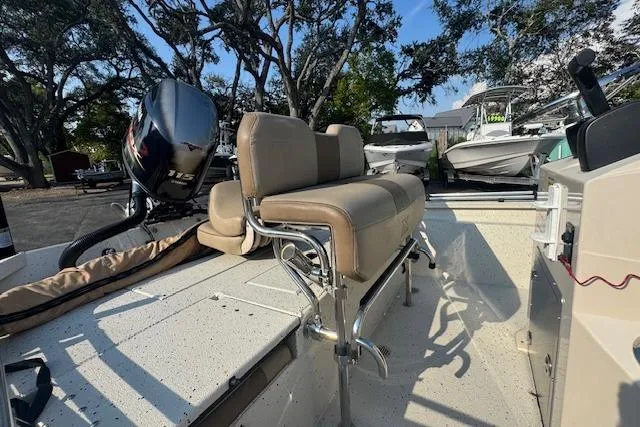 Slide: The Image of 2019 Xpress H20 boat interior with seating and outboard motor in a sunny outdoor setting. - 19