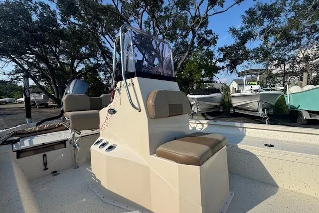 Slide: The Image of 2019 Xpress H20 boat with console seating, surrounded by trees and parked boats. - 21