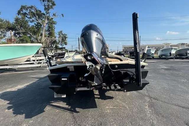 Slide: The Image of 2019 Xpress H20 boat rear view with motor, parked on asphalt. - 6