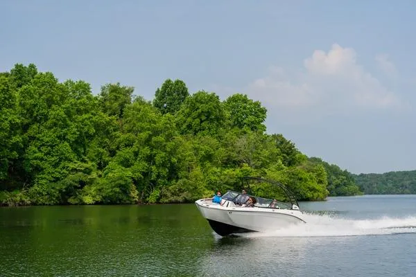 Slide: The Image of 2026 Yamaha Boats 252S cruising on a scenic lake with lush green trees. - 6