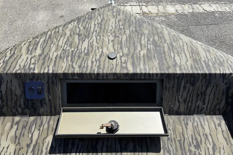 Slide: The Image of 2026 SeaArk Shadow 19 V Center Console with camo pattern and open storage compartment. - 2