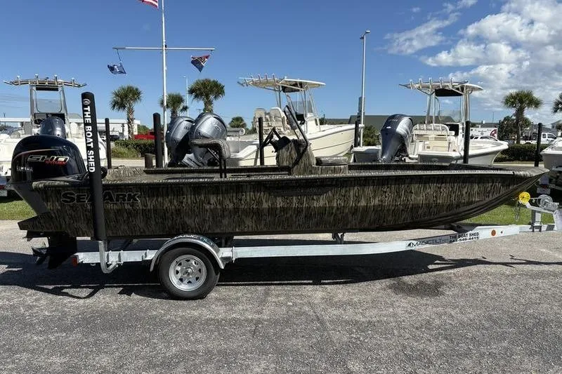 Slide: The Image of 2026 SeaArk Shadow 19 V Center Console boat on trailer, parked outdoors under clear sky. - 14