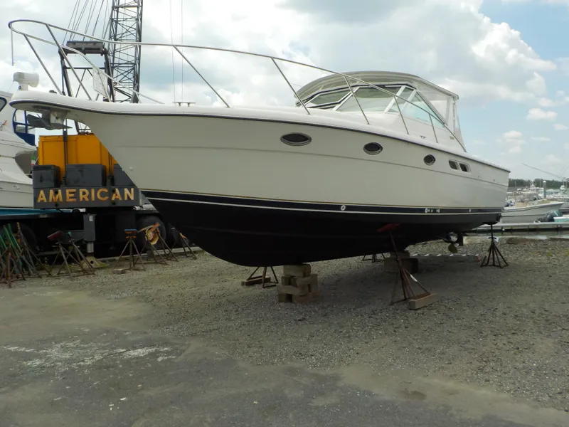 Slide: The Image of 2003 Tiara Yachts 3100 Open boat on dry dock, side view, under cloudy sky. - 0